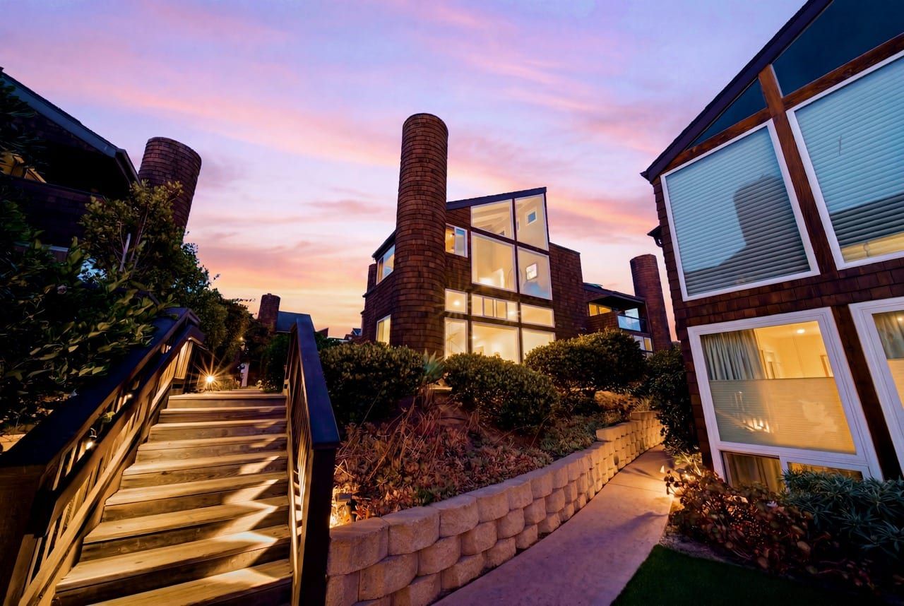 The steps between the buildings at dusk, windows lit gold against a pink and violet sky