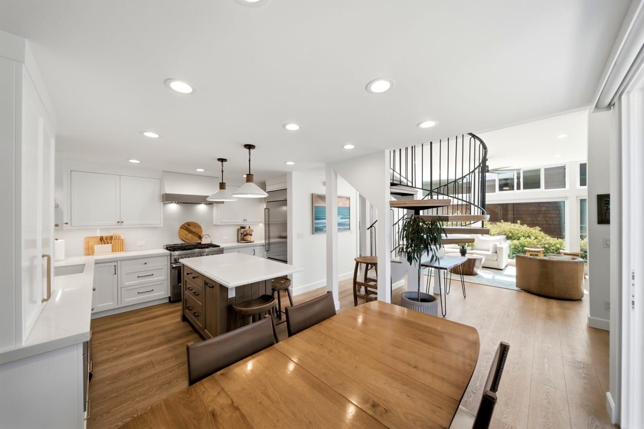 Looking across the dining table to the kitchen and the spiral staircase beyond