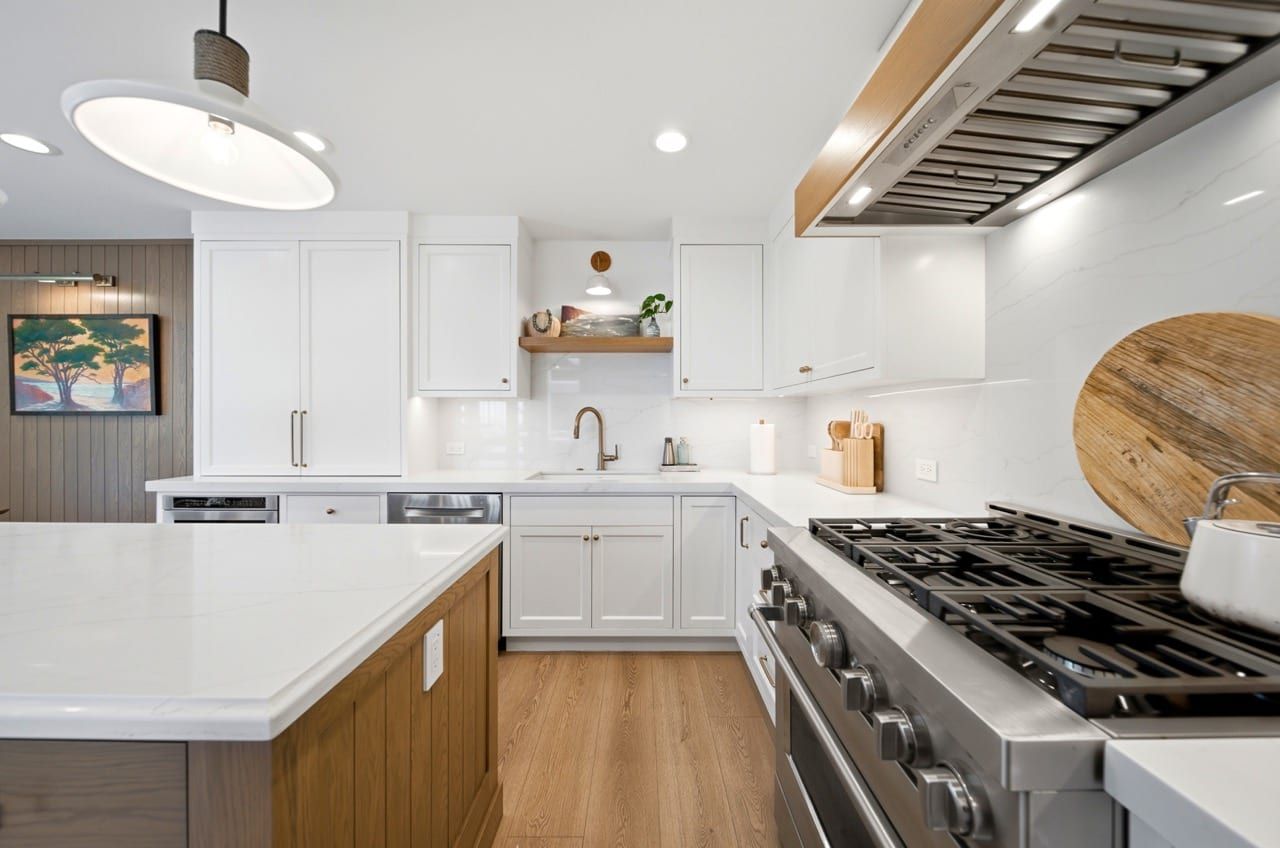 The professional stainless gas range beneath an oak-trimmed vented hood