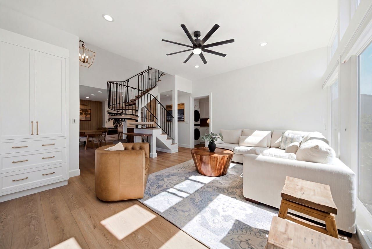 The living room with the iron spiral staircase rising to the upper floor