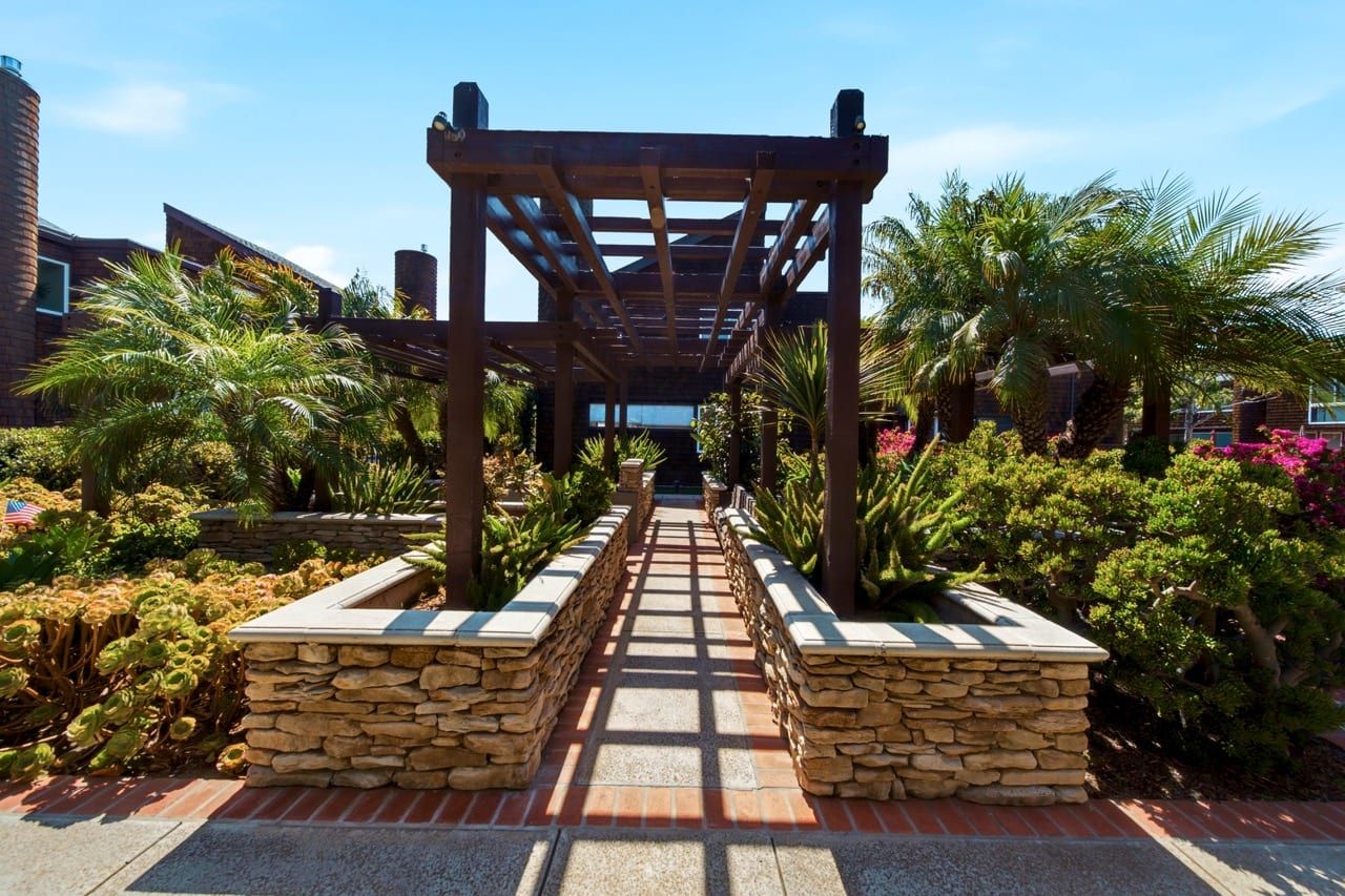 A pergola-covered walkway through the community planting