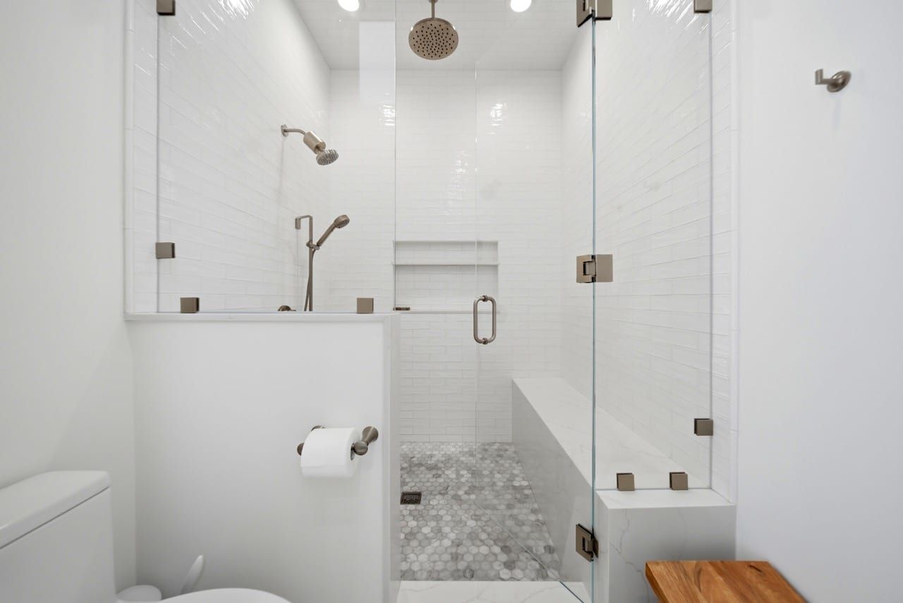 The primary walk-in shower, tiled floor to ceiling with a bench seat