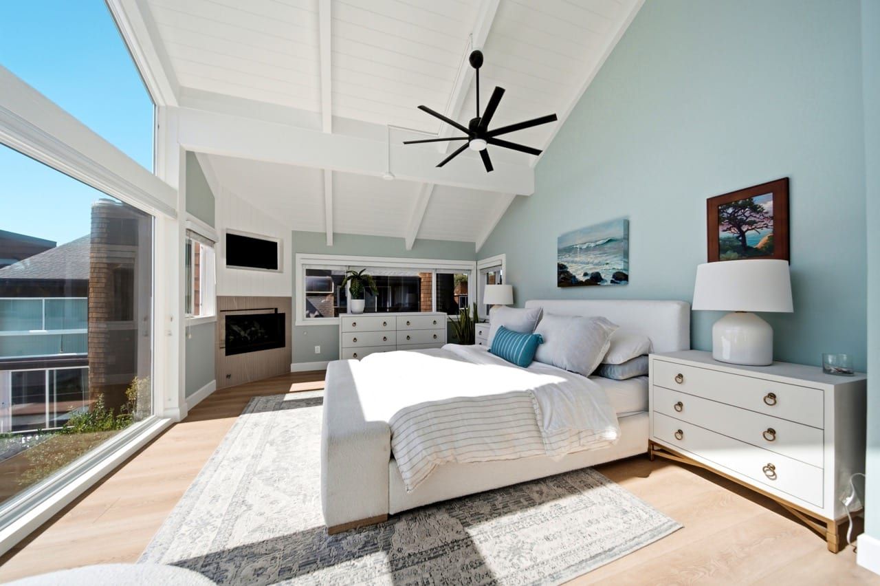 The primary bedroom, with a fireplace set into the wall opposite the bed
